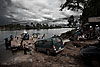 Makeshift Ferry Photo: Somewhere between the Thai border and Sihanoukville, Cambodia.  Rainy weather and unpaved roads delayed our 8 hour van-ride to over 12 hours.  Rivers en-route are crossed on the backs of these twin diesel engine driven makeshift monstrosities, complete with drawbridge.  The ferries function, albeit slowly but the problem was the inability of automobiles to climb up and down these steep, slippery ramps of mud.  It's all part of a day's journey for a backpacker, especially one who cares to experience the day to day life of the average Cambodian.