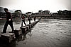 Footbridge Photo: Chinese tourists use a slightly unsafe footbridge to cross a river.  The footbridge is a drawing point for tourists to this village but in the 4 days I spent at Fenghuang, I personally saw 3 people fall into the river.  Bruised egos aside, no one was injured.