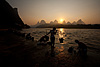 Chores & Karsts Photo: Women scrub laundry along the bank of the river.