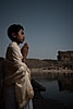 Priest & Temple Photo: A young brahman poses in front of the Bhutanatha Temple and water tank in Badami.