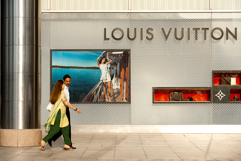 A pair of ethnic Indian-Malaysians walk in front of a Louis Vuitton store. - Kuala Lumpur, Malaysia - Daily Travel Photos