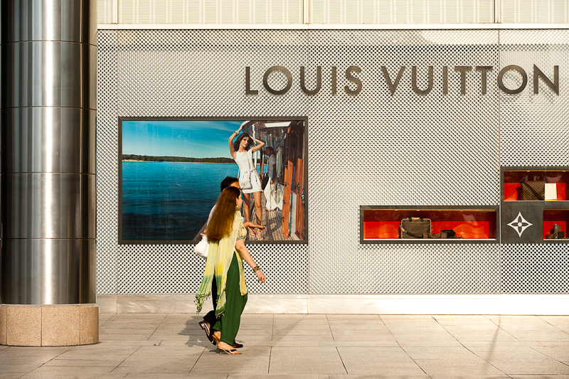 A pair of ethnic Indian-Malaysians walk in front of a Louis Vuitton store. - Kuala Lumpur, Malaysia - Daily Travel Photos