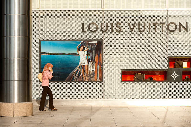 An ethnic Malay woman walks in front of a Louis Vuitton store. - Kuala Lumpur, Malaysia - Daily Travel Photos