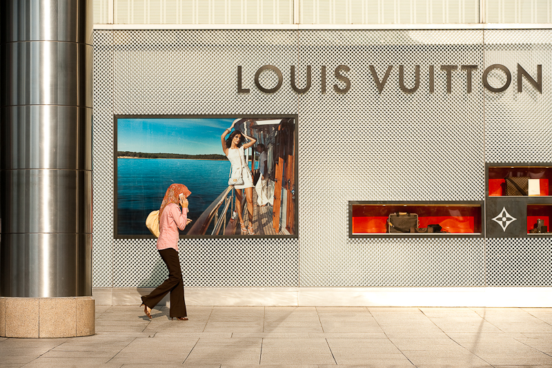 An ethnic Malay woman walks in front of a Louis Vuitton store. - Kuala Lumpur, Malaysia - Daily Travel Photos