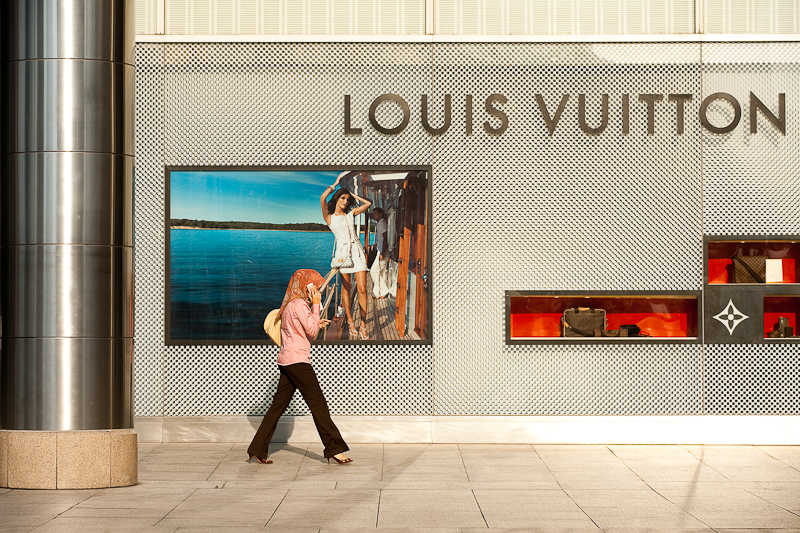 An ethnic Malay woman walks in front of a Louis Vuitton store. - Kuala Lumpur, Malaysia - Daily Travel Photos