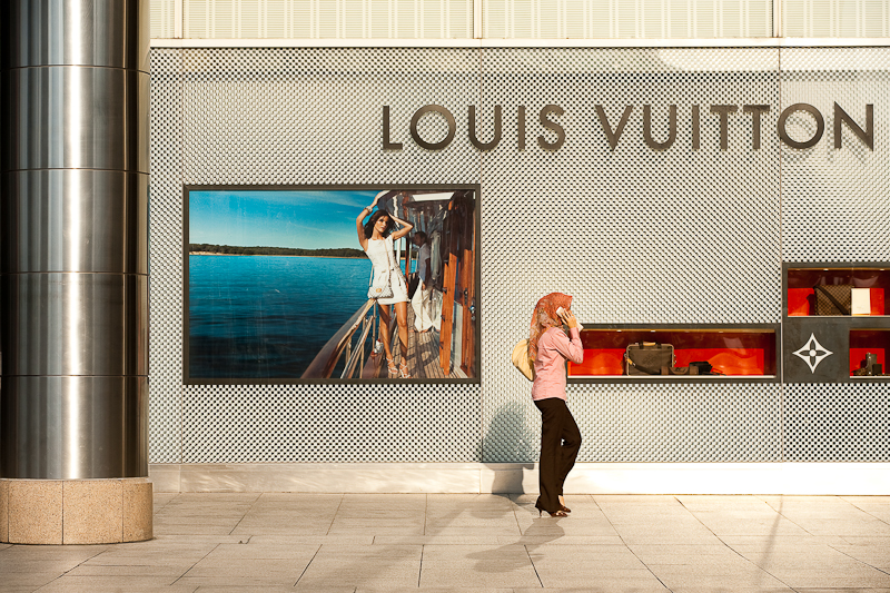 An ethnic Malay woman walks in front of a Louis Vuitton store. - Kuala Lumpur, Malaysia - Daily Travel Photos