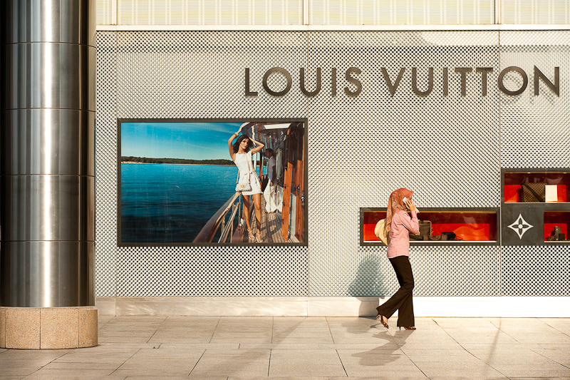 An ethnic Malay woman walks in front of a Louis Vuitton store. - Kuala Lumpur, Malaysia - Daily Travel Photos