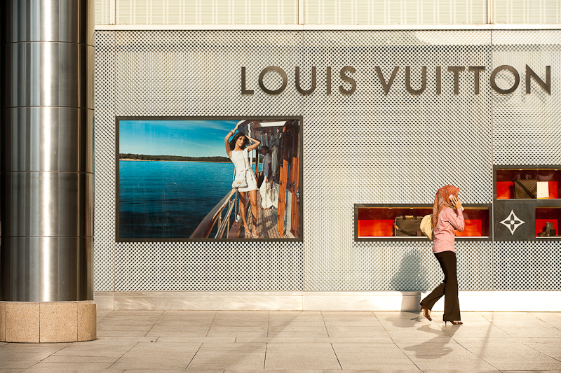 An ethnic Malay woman walks in front of a Louis Vuitton store. - Kuala Lumpur, Malaysia - Daily Travel Photos