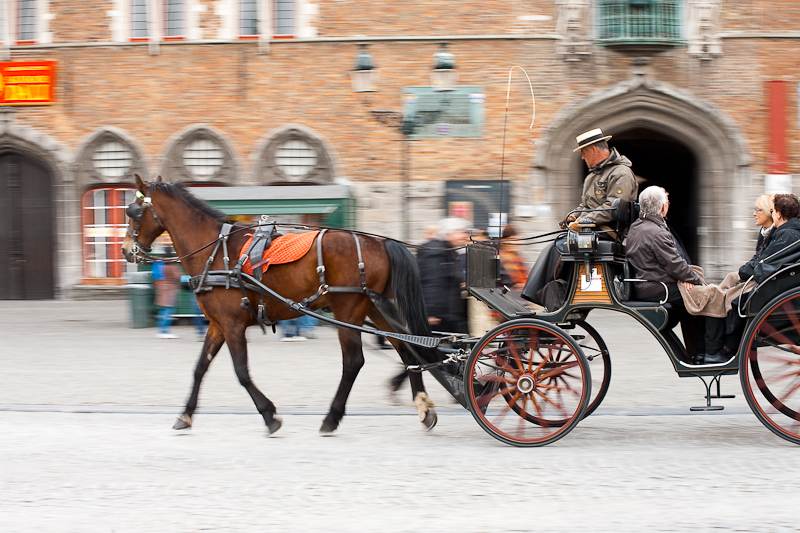 A tourist horse and buggy glide past the belfry on Grote Markt. - Brugge, Belgium - Daily Travel Photos