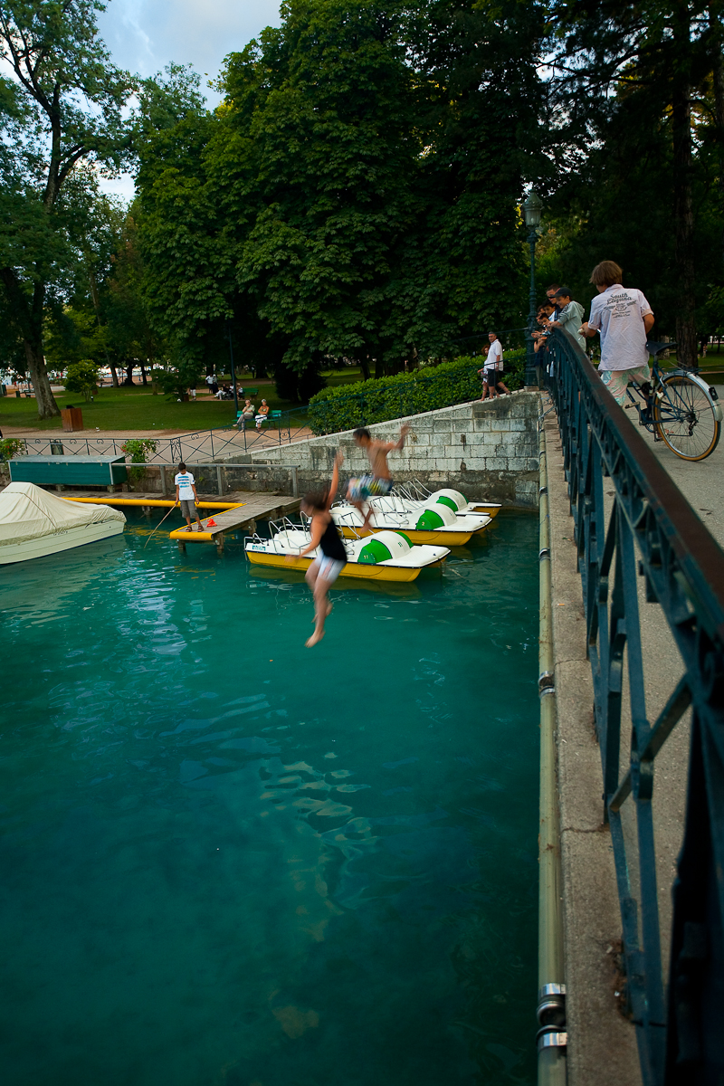 French children jump from a bridge into beautiful lake Annecy - Annecy, France - Daily Travel Photos