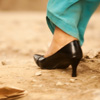 Off-Roading Photo: A high-heeled woman expertly navigates a typical unpaved Indian road.