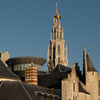 Queasy Cruise Photo: A jumble of tourist attractions including Het Steen and Onze Lieve Vrouwekathedraal seen from the Scheldt river.