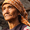 Ladies Night Photo: A local woman idles in front of her traditionally built house. 