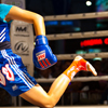 Wai Khru Ram Muay Photo: A female muay thai fighter performs a ritualistic dance, the wai khru ram muay prior to her bout.  Here she twists her body and repeated kicks her rear leg up and down.