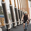 Pedestrians Rama VIII Bridge (Before-After) Photo: A Thai bicyclist rides near the repetitive suspension cables on the Rama VIII bridge in Bangkok.