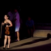 Female Thai Violinist Photo: A Thai violinist reacts to an audience member at an open-air show in Bangkok.