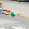 Songkran Talcum Powder Photo: A young child throws a paste comprised of water and talcum powder at a moving tuk-tuk during Songkran.