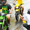 Songkran Motorcycle Attack Photo: A water fighter fires his gun under the helmets of motorcycle riders during Songkran water festival.