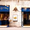 Annecy Arch Photo: A beautifully blue storefront seen through an arch in the historic old town of Annecy.