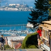 Peak & Prison Photo: The Hyde Street cable car descends at its peak with Alcatraz Prison in the background.