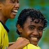 Rainy Ride Photo: A pair of laughing young boys ride bicycles in the rain in Dili, East Timor (ARCHIVED PHOTO on the weekends - originally photographed 2006/12/07).