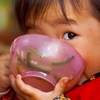 Dubious Deadeye Photo: A young Chinese girl plants her face in her food bowl while keeping a wary eye on the photographer (ARCHIVED PHOTO on the weekends - originally photographed 2007/09/30).